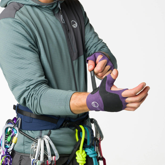 Side profile image of rock climber tightening his purple Wild Country Crack Gloves