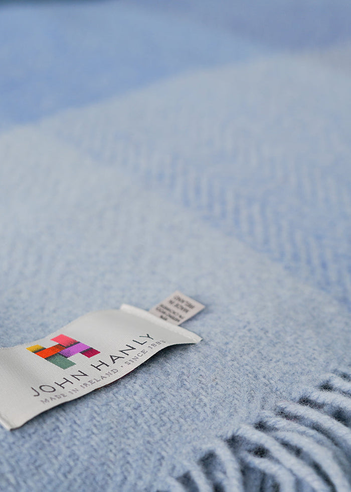Blue blanket with a visible brand label on a soft focus background