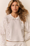 White eyelet accented pullover against a white background