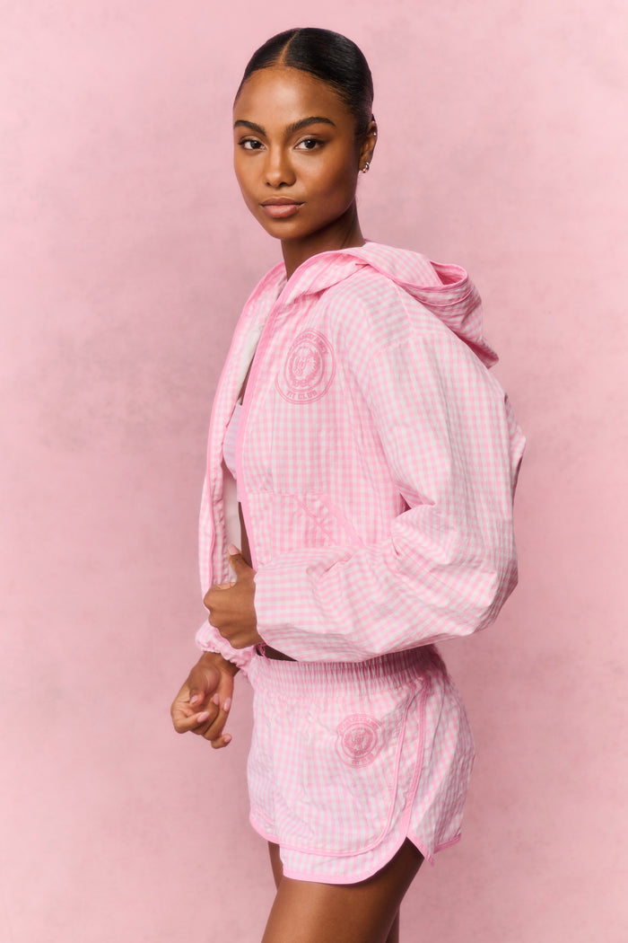 Person wearing a pink checkered workout outfit on a pink background