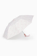 White umbrella with a subtle pink bow pattern on a white background