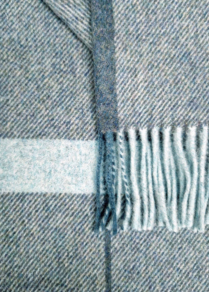 Close-up of a blue and gray plaid fabric with fringed edge