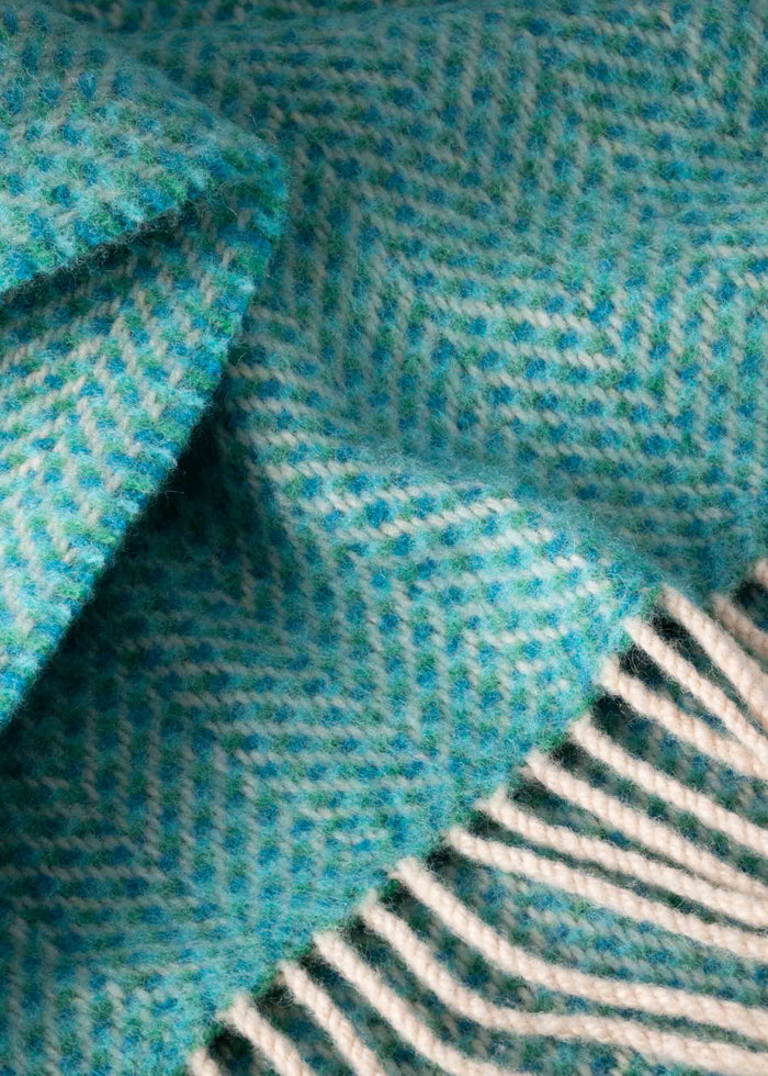 Close-up of a teal and gray textured fabric with a fringed edge