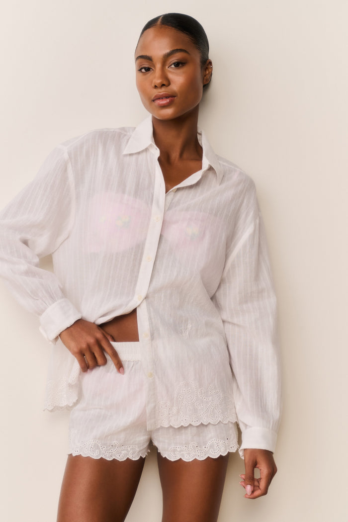 Woman wearing a white outfit with a plain background