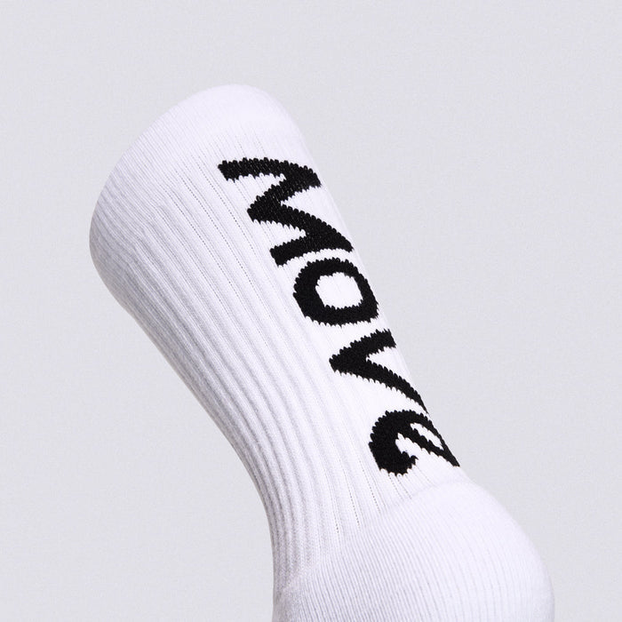 A close-up of a white ribbed crew sock with the word 'MOVE' knitted in black across the side, shown against a light gray background.