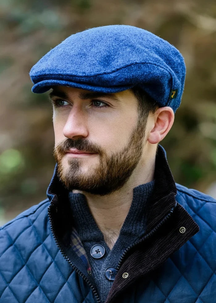 Man wearing a mucros trinity blue cap and quilted jacket outdoors