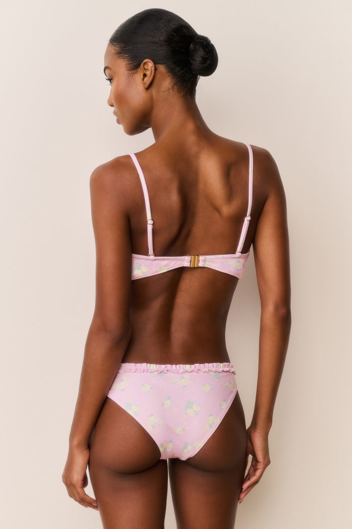 Woman wearing a pink bikini with a white background