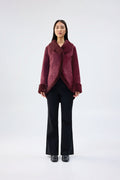 Burgundy faux fur jacket with shawl collar and wrap-front, contrast plush cuffs, worn over black trousers, front view