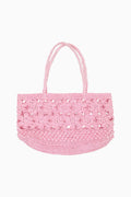 Pink woven handled bag against white background