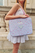 Person holding a floral laptop case with a heart design and 'stella' name  custom monogram outdoors.