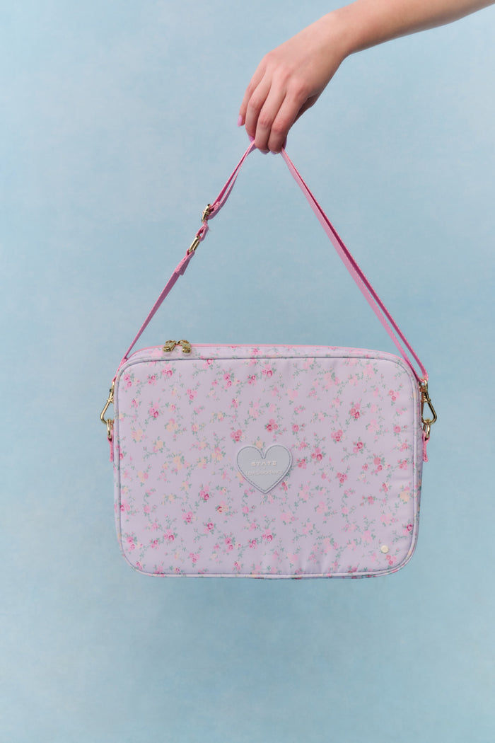 Pink floral laptop bag with a heart design on a light blue background