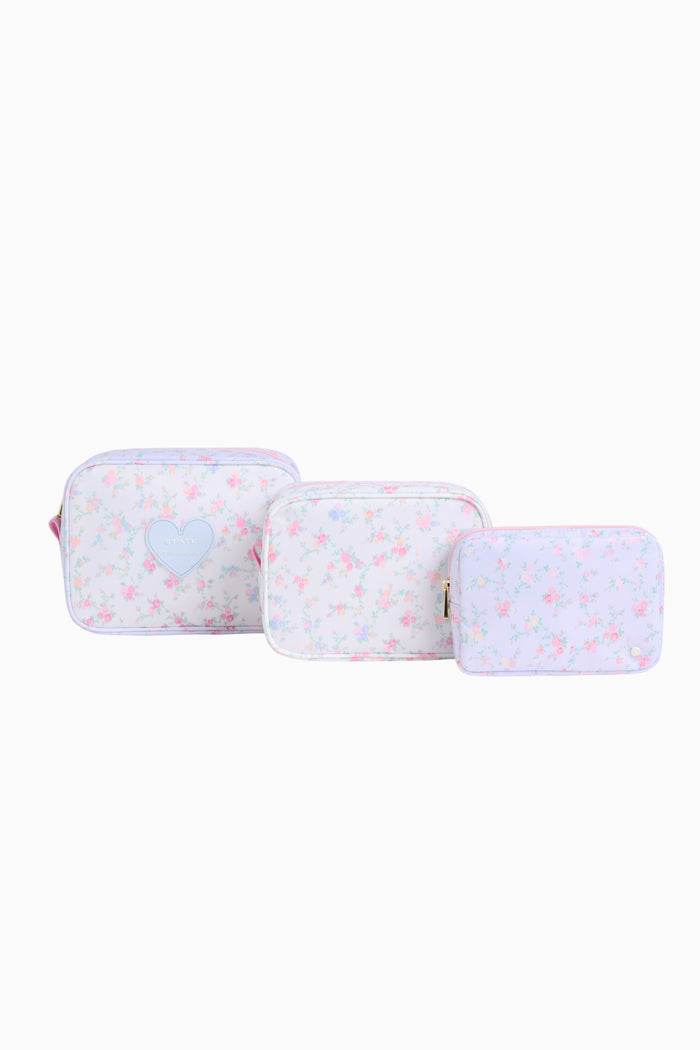 Three light blue travel cases with flower patterns on a white background