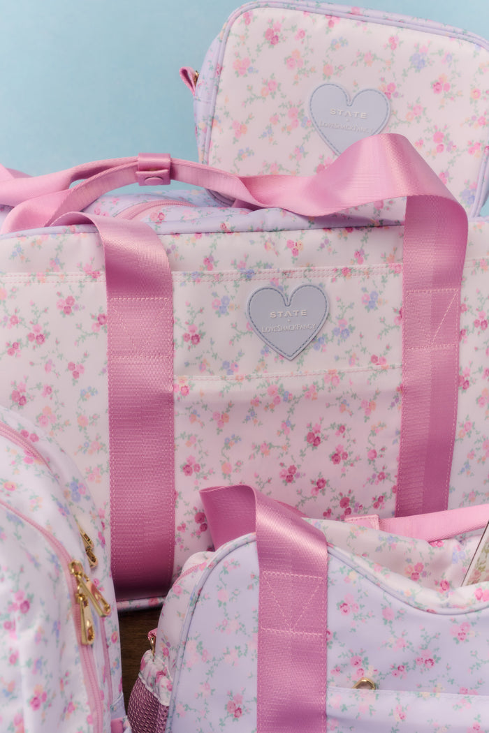 Floral-patterned bags with pink ribbons and heart designs on a light blue background