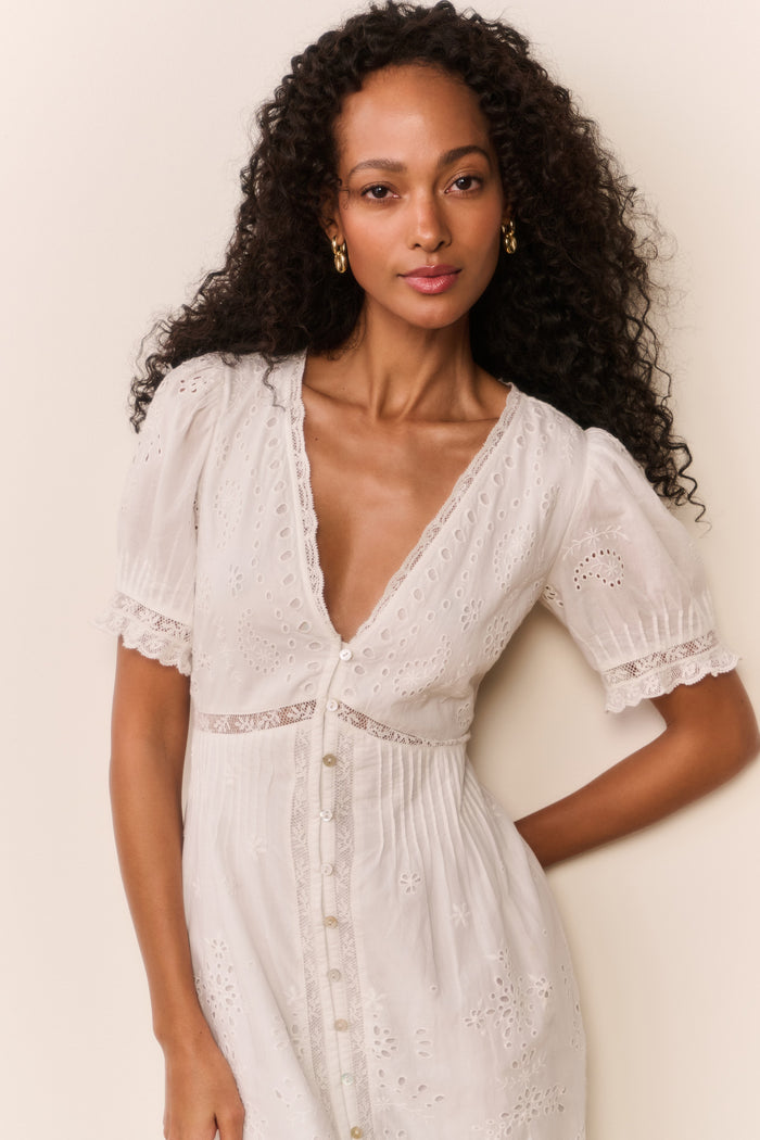 Woman wearing short sleeve white lace eyelet cutout long dress