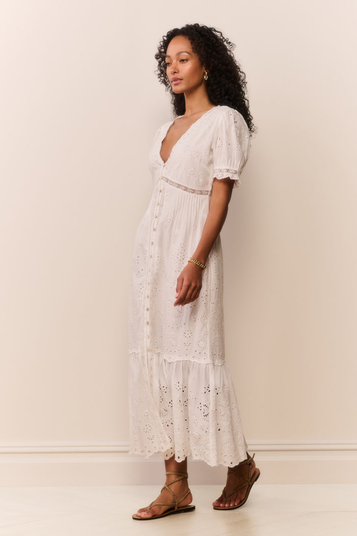 Woman wearing short sleeve white lace eyelet cutout long dress