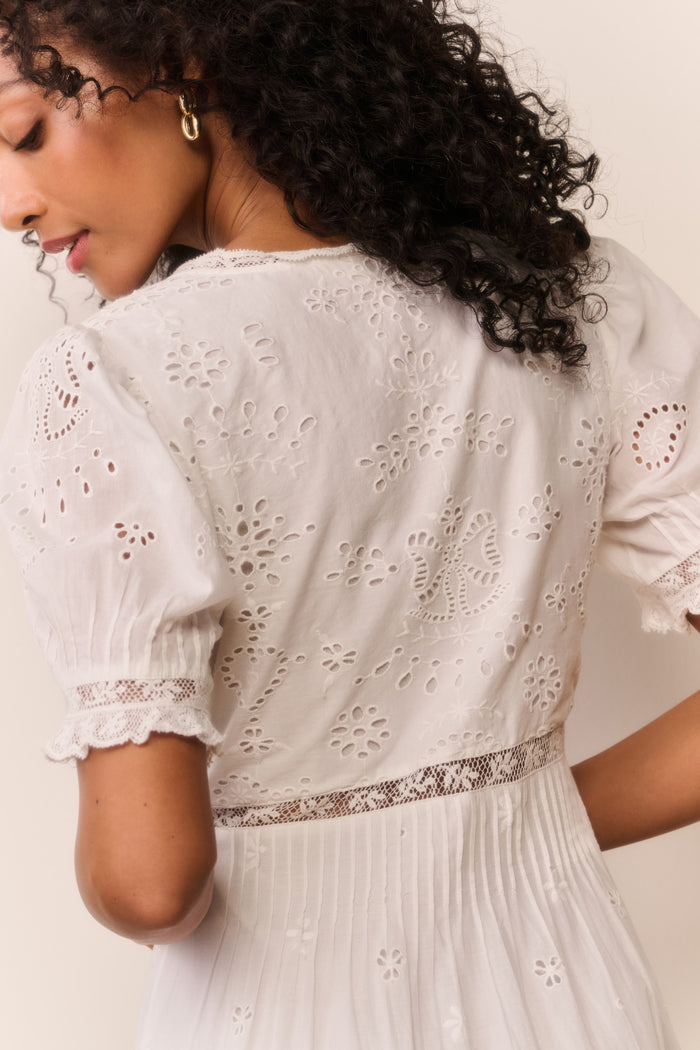 Woman wearing short sleeve white lace eyelet cutout long dress