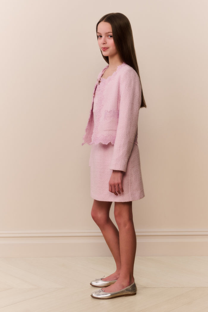 Girl wearing pink linen mini dress with matching lace trim evening jacket