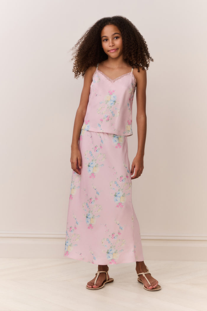 Girl wearing a pink floral matching cami and maxi skirt against a beige background