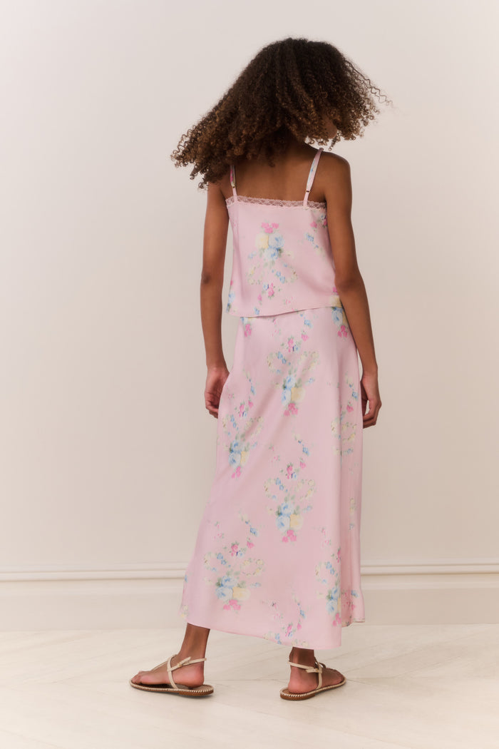 Girl wearing a pink floral matching cami and maxi skirt against a beige background